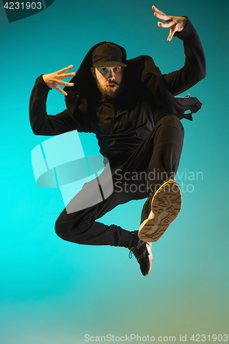 Image of The silhouette of one hip hop male break dancer dancing on colorful background