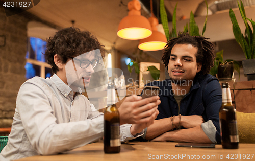 Image of men with smartphones drinking beer at bar or pub