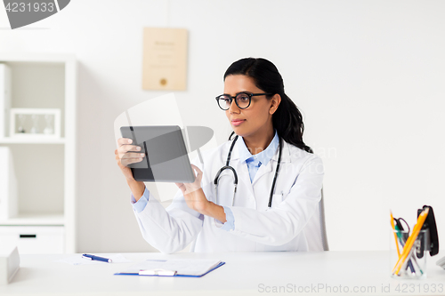 Image of doctor with tablet pc and clipboard at hospital