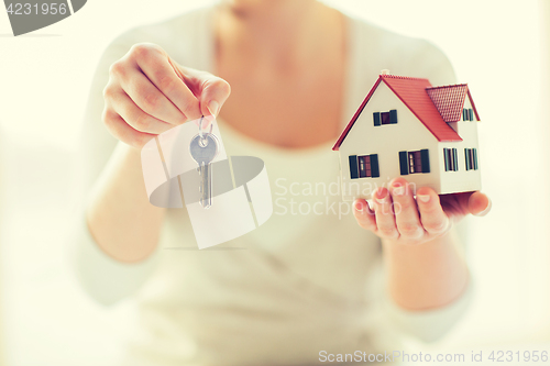 Image of close up of hands holding house model and keys