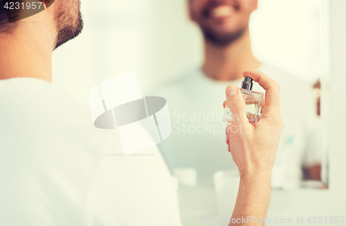 Image of close up of man perfuming with perfume at bathroom