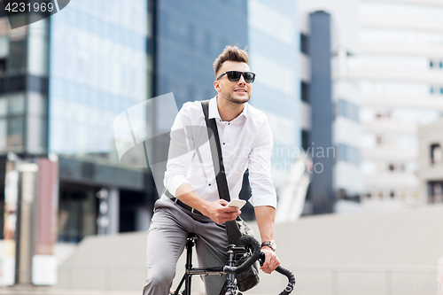 Image of man with bicycle and smartphone on city street