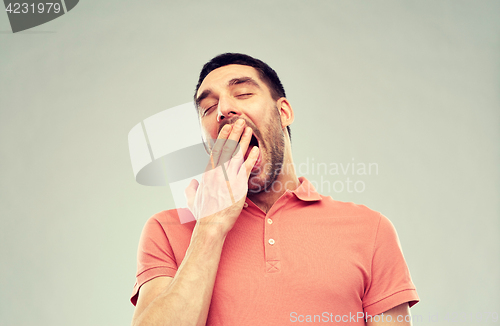 Image of yawning man over gray background
