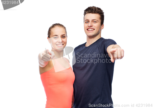 Image of happy sportive man and woman pointing finger