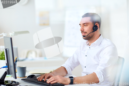 Image of businessman with headset and computer at office