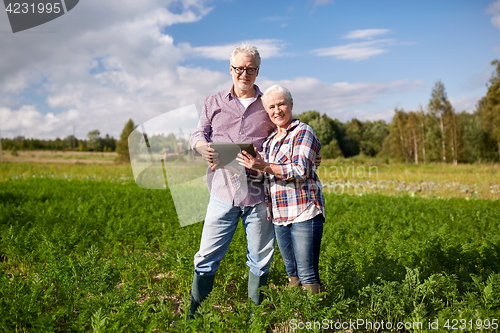 Image of happy senior couple with tablet pc at summer farm