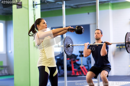 Image of man and woman with weights exercising in gym