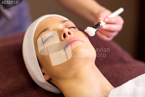 Image of beautician applying facial mask to woman at spa