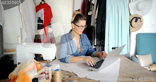 Image of Tailor using laptop in parlour