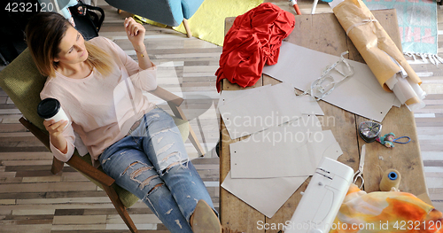 Image of Female tailor having rest in workshop