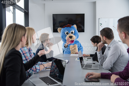 Image of boss dresed as bear having fun with business people in trendy of