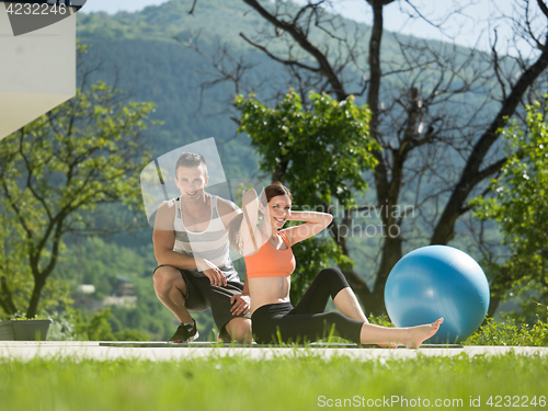 Image of woman with personal trainer doing morning yoga exercises