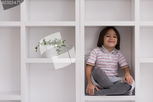 Image of young boy posing on a shelf