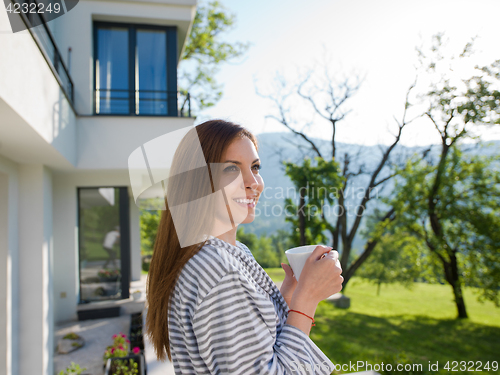 Image of woman in a bathrobe enjoying morning coffee