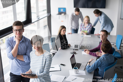 Image of Two Business People Working With Tablet in office