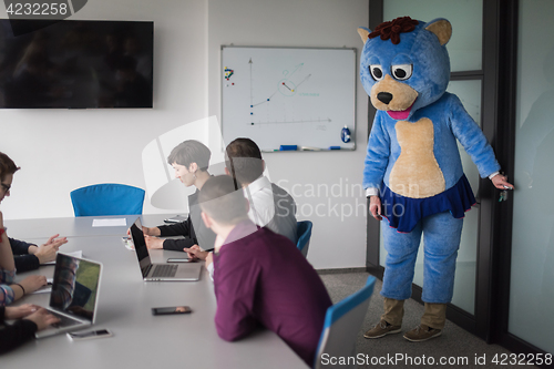 Image of boss dresed as bear having fun with business people in trendy of