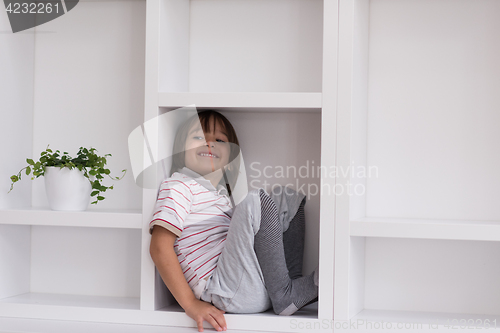 Image of young boy posing on a shelf