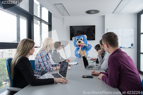 Image of boss dresed as bear having fun with business people in trendy of