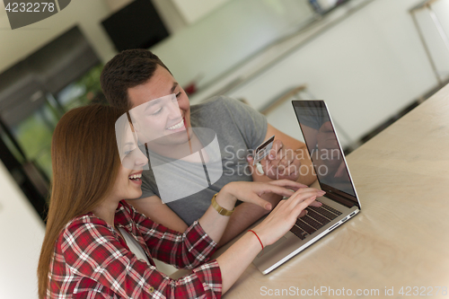 Image of happy young couple buying online