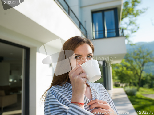 Image of woman in a bathrobe enjoying morning coffee