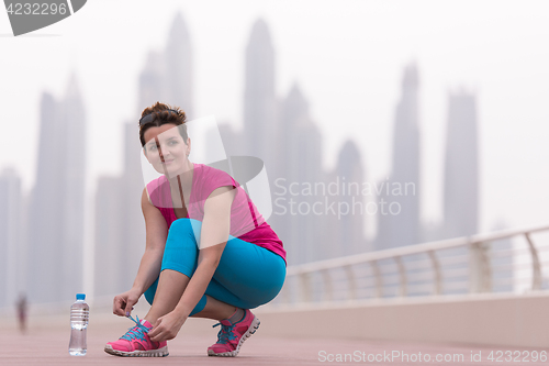 Image of woman tying shoelaces on sneakers