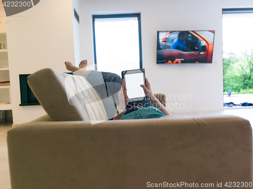 Image of woman on sofa using tablet computer