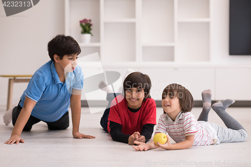 Image of boys having fun with an apple on the floor