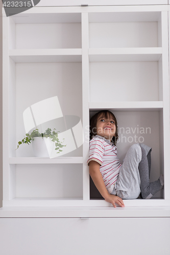 Image of young boy posing on a shelf