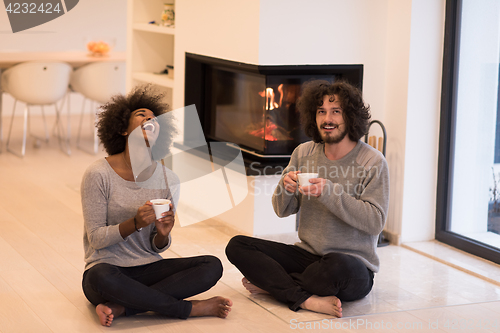 Image of multiethnic couple  in front of fireplace