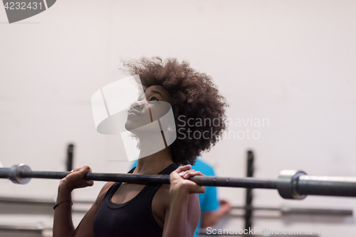 Image of black woman lifting empty bar