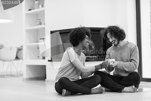 Image of multiethnic couple  in front of fireplace