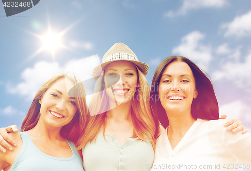 Image of group of happy smiling women or friends over sky