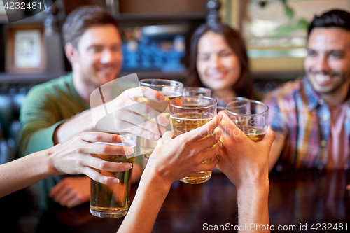 Image of happy friends drinking beer at bar or pub