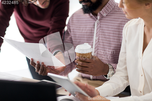 Image of business team with papers and coffee at office