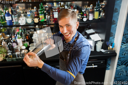 Image of happy barman with shaker preparing cocktail at bar