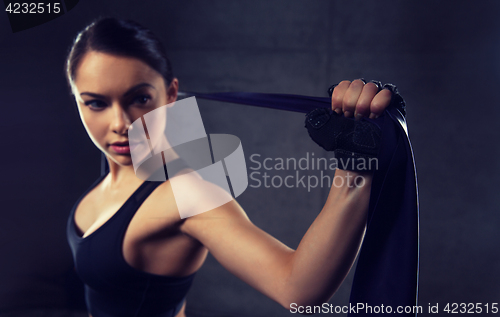 Image of woman with expander exercising in gym