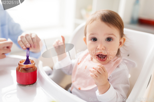 Image of mother feeding baby with puree at home