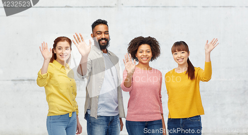 Image of international group of happy people waving hands