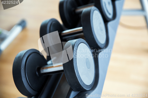 Image of close up of dumbbells and sports equipment in gym