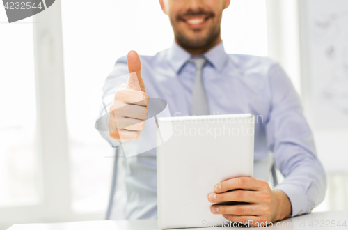 Image of businessman with tablet pc showing thumbs up