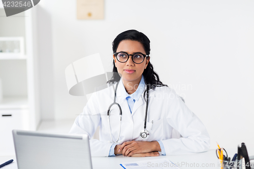 Image of doctor with laptop and clipboard at hospital