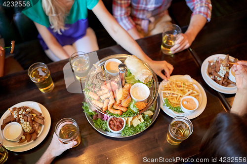 Image of friends eating and drinking at bar or pub