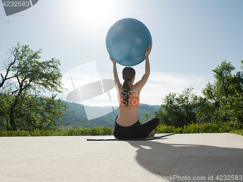 Image of woman doing exercise with pilates ball