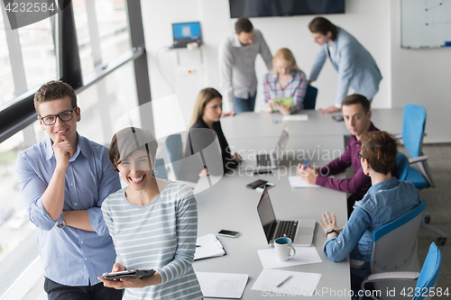 Image of Two Business People Working With Tablet in office