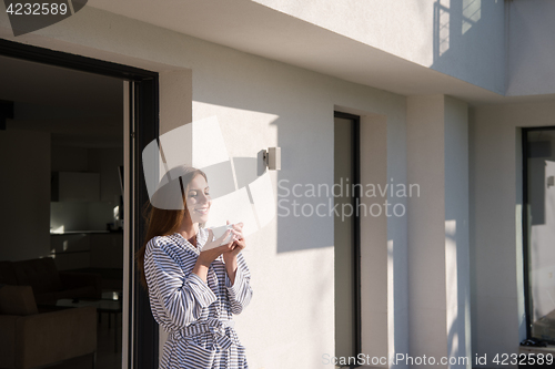 Image of woman in a bathrobe enjoying morning coffee