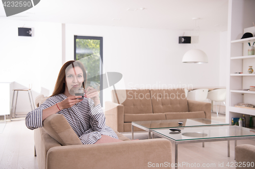 Image of young woman in a bathrobe enjoying morning coffee