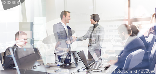 Image of Business people shaking hands in moder corporate office.