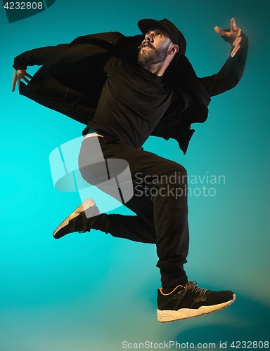 Image of The silhouette of one hip hop male break dancer dancing on colorful background