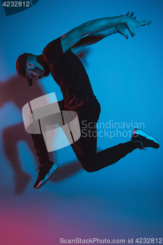 Image of The silhouette of one hip hop male break dancer dancing on colorful background