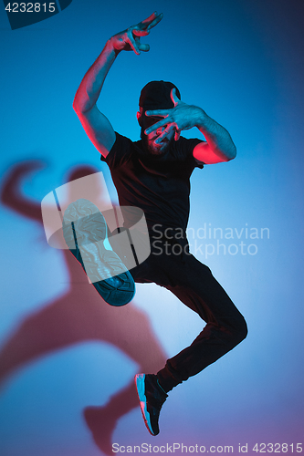 Image of The silhouette of one hip hop male break dancer dancing on colorful background